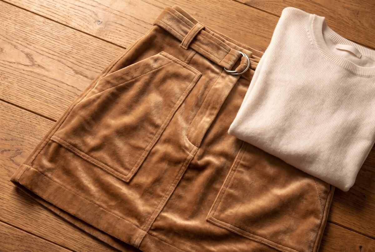 Camel velvet belted skirt with front pockets laid flat on warm wood, upcycled fabric