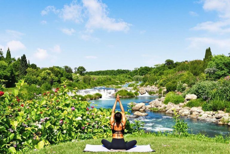 Person practicing yoga in a peaceful natural setting.